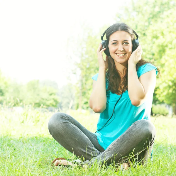ヘッドフォンを屋外での美しさ若い女性 — ストック写真