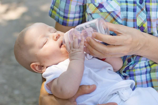 Bebê bebe água de garrafa — Fotografia de Stock