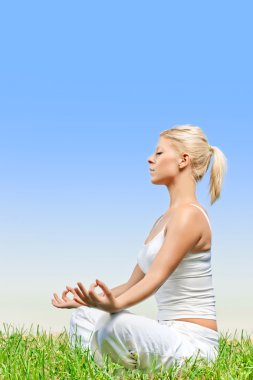 Beautiful relaxed young woman meditating outdoors clipart