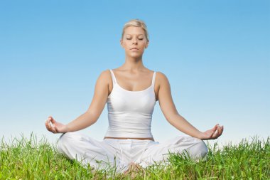 Portrait of relaxed young woman meditating outdoors clipart