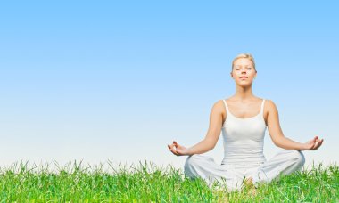 Young woman practicing yoga meditating outdoors clipart