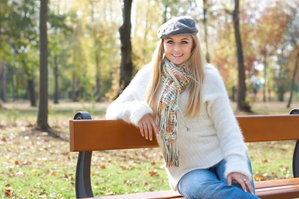 Vrouw zittend op een park bank — Stockfoto