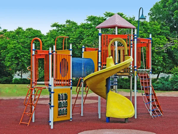 Un colorato parco giochi pubblico in un giardino — Foto Stock