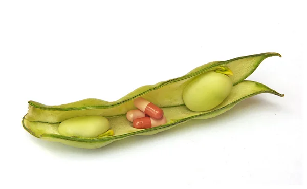 Pills in green beans as a symbol of green medicine — Stock Photo, Image