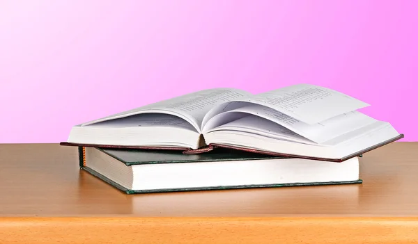 Öppna bok på skrivbord på rosa bakgrund — Stockfoto