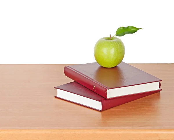 Яблоко и книги на столе — стоковое фото