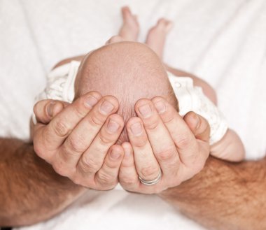 Father holding the head of baby clipart