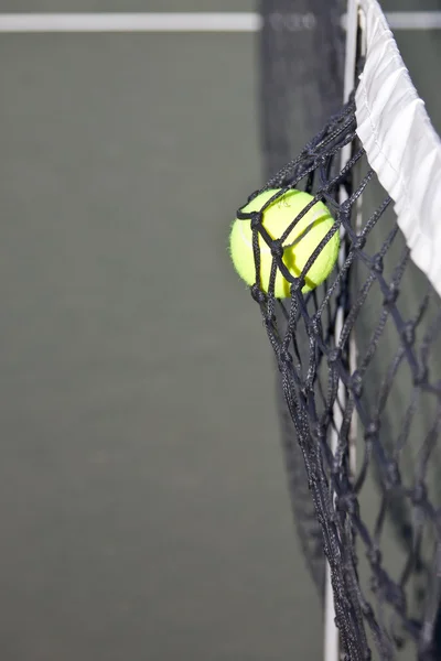 Теннисный мяч бьет по сетке на корте — стоковое фото