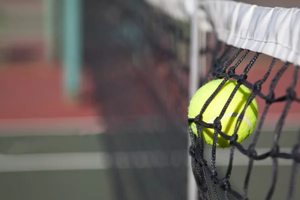 Теннисный мяч бьет по сетке на корте — стоковое фото