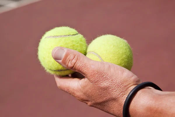 Tennisplayer trzymając dwie kule w ręku — Zdjęcie stockowe