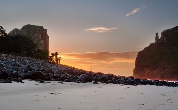 Paisagem do nascer do sol na praia com pedras e penhascos — Fotografia de Stock
