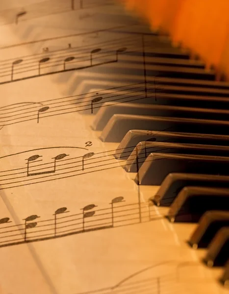 Bladmuziek gemengd over piano in zacht licht — Stockfoto