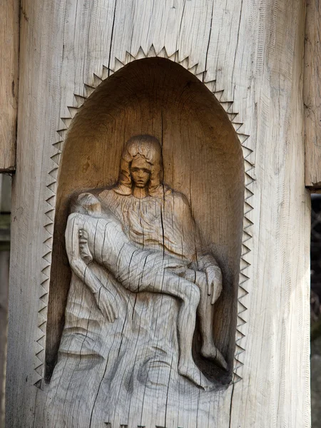 在一个小教堂圣母怜子图刻在一根树干 — 图库照片