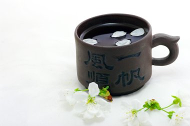 Green tea in a chinese cup with a cherry flower clipart