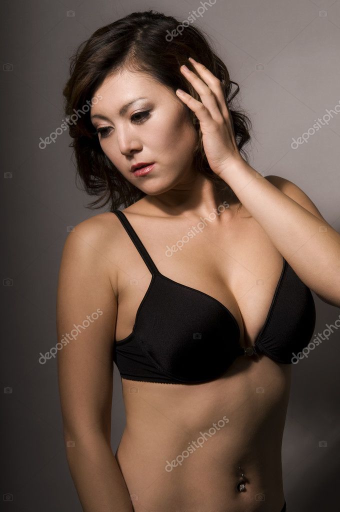 Foto de Young asian beautiful woman in sexy underwear posing in dark  background do Stock