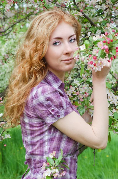 Elma çiçeği arasında Kızıl saçlı kadın — Stok fotoğraf