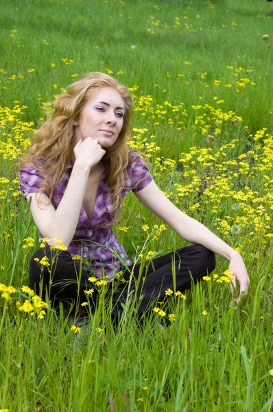 Donna seduta tra fiori gialli — Foto Stock