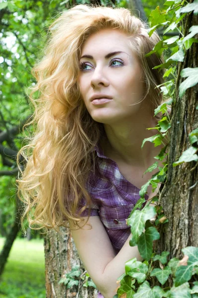 Žena poblíž stromu s horolezec rostlin — Stock fotografie