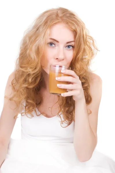 Woman drinking juice in bed — Stock Photo, Image