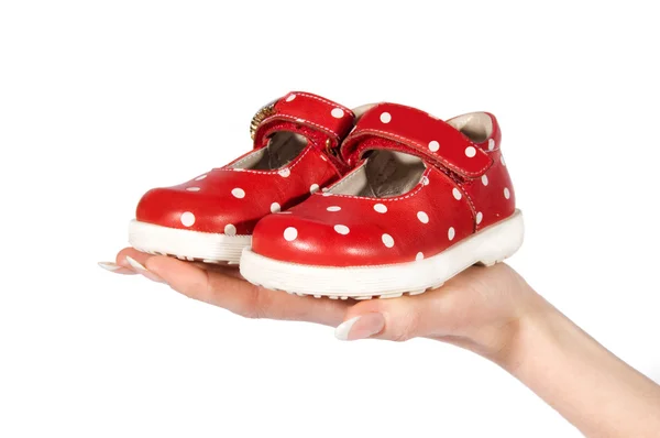 Vrouw hand met baby schoenen — Stockfoto