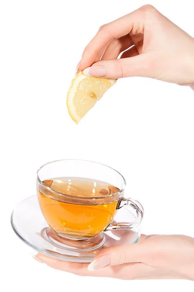 Hand adding lemon to tea — Stockfoto