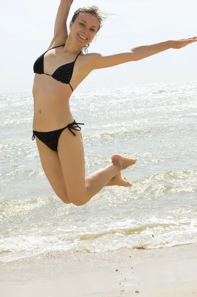Jumping on sea shore — Stock Photo, Image