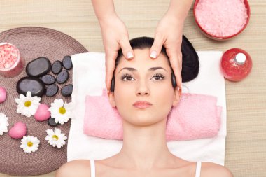 Head massage in a spa center clipart