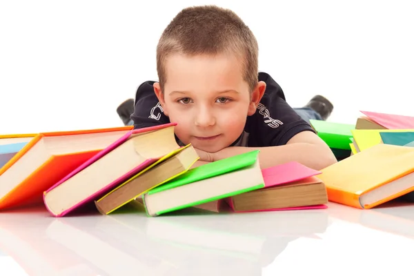 Niño con muchos libros tirados en el suelo —  Fotos de Stock