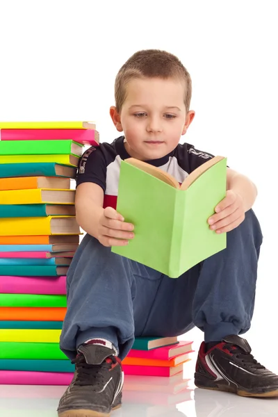 Menino sentado em livros — Fotografia de Stock
