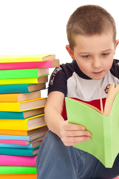Przedszkolak opierając się stos książek — Zdjęcie stockowe