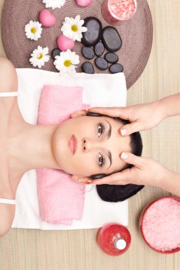 Head massage in a spa center clipart