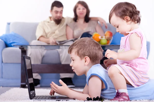 Baby girl and little boy playing on lap top — Stock Photo, Image