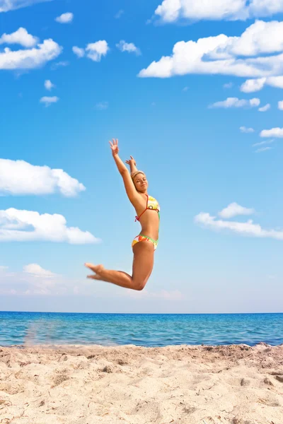 Frau springt in den Strand — Stockfoto
