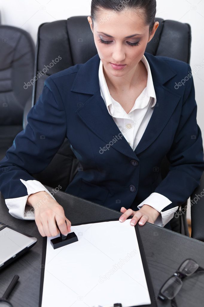 Businesswoman stamping documents