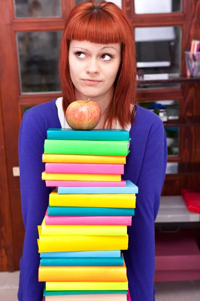 Девушка со стопкой цветной книги — стоковое фото