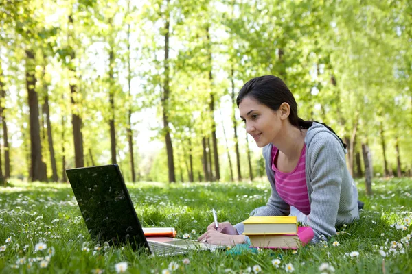 Νεαρή γυναίκα που σπουδάζουν στο πάρκο — Φωτογραφία Αρχείου