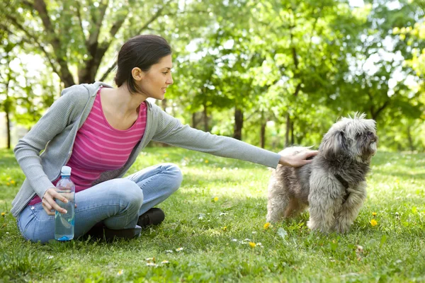 Mladá dívka se psem v parku — Stock fotografie