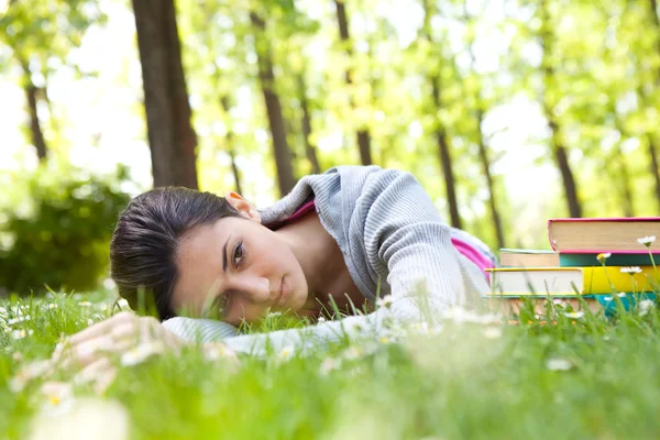 Chica estudiante cansado acostado en la hierba — Foto de Stock