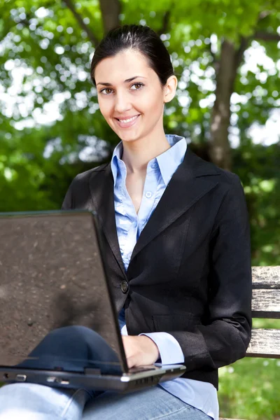 Vrouw die op laptop buiten werkt — Stockfoto