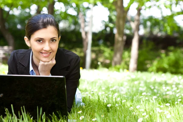 Młoda kobieta działa na laptopie w polu — Zdjęcie stockowe