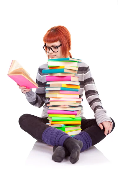 Студент сидит с грудой книг — стоковое фото