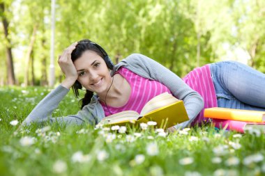 Smiling woman with book in nature clipart