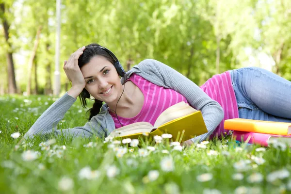 Lächelnde Frau mit Buch in der Natur — Stockfoto
