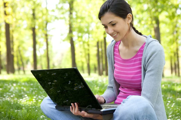 Étudiant avec ordinateur portable dans le parc — Photo