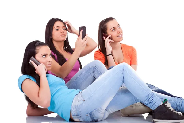 Three girls with phones — Stok fotoğraf
