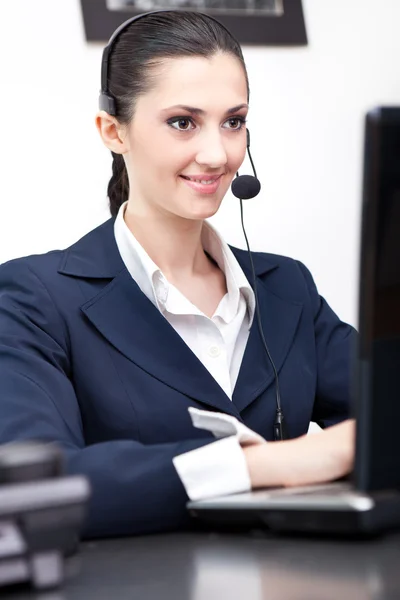 Empresária trabalhando no computador com fone de ouvido — Fotografia de Stock