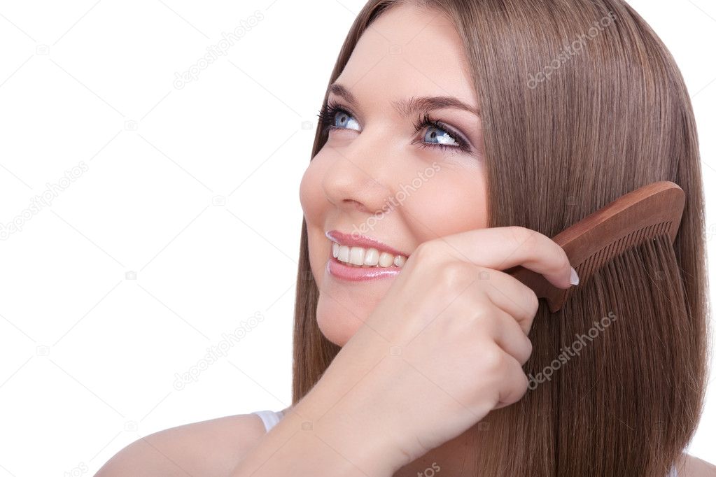 Beautiful young woman combing her hair