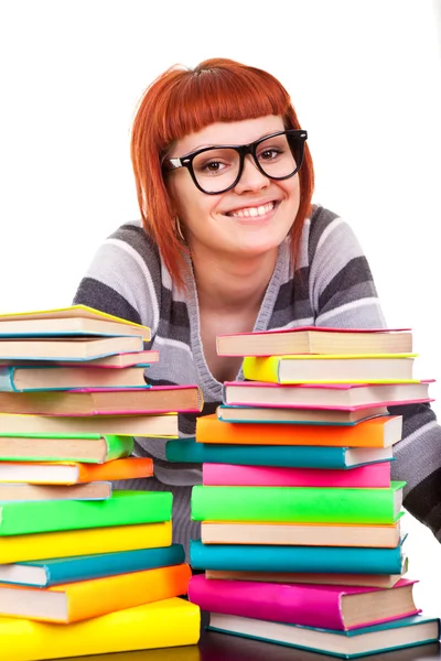 Leende flicka med hög med böcker — Stockfoto