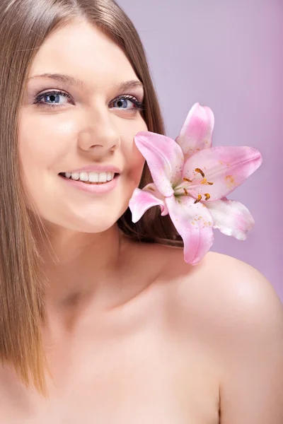 Vacker kvinna med blomma på axel — Stockfoto