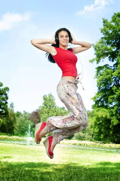 Glad tjej som hoppar i park — Stockfoto